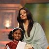 Aishwarya Rai felicitates a child at the Tribute to the Legend of Pure Love concert