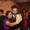 Abhishek Bachchan clicks a selfie with a guest at the Press Conference of 60th Filmfare Awards 2014