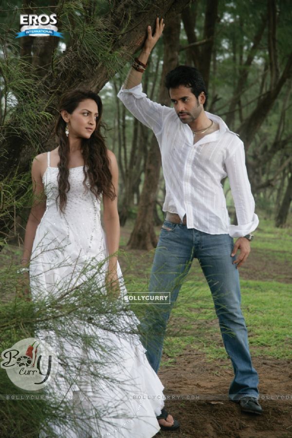 Esha Deol and Tusshar Kapoor standing under a tree (11587)