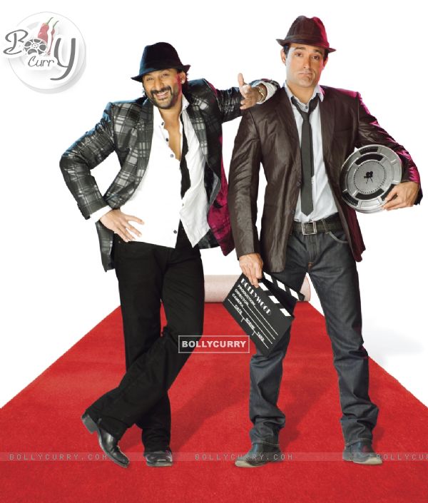Arshad Warsi giving style and Akshay Khanna standing with a shooting products in Shortkut