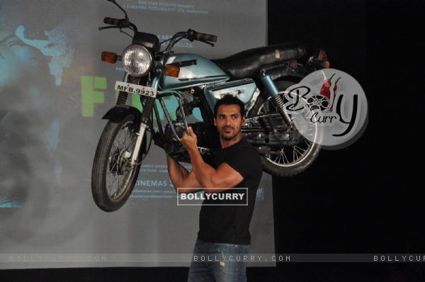 John Abraham holds up bike during the promotion of their film 'Force' in Mumbai
