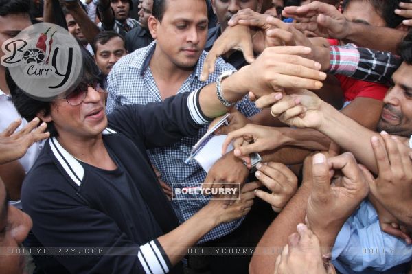 Fans crowd around Shahrukh Khan as he arrives at Big Cinemas