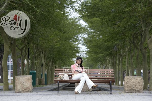Prachi Desai sitting on a bench