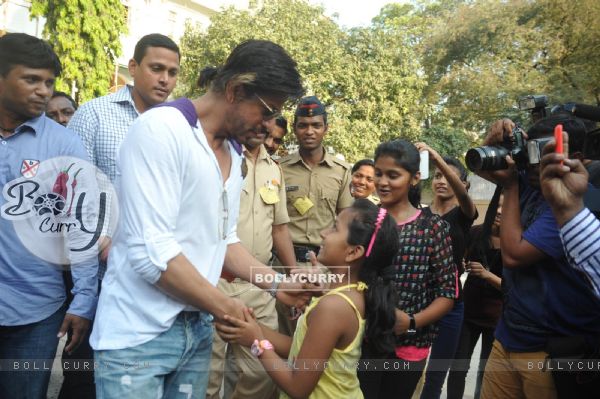 Shahrukh Khan interacts with a fan at a polling station in Mumbai