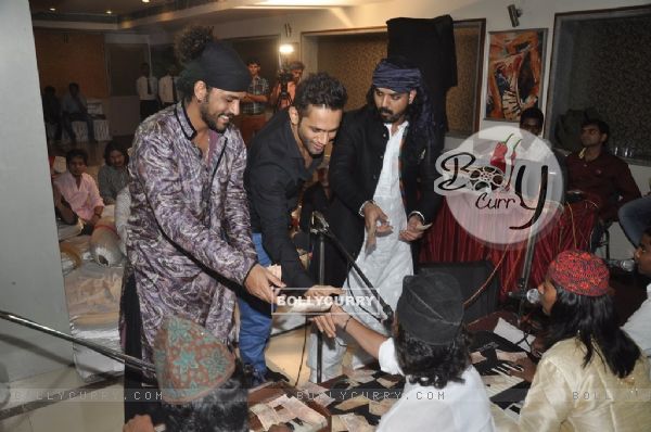 Sharib-Toshi give some money as a token of gratitude at the Sufi Mehfil