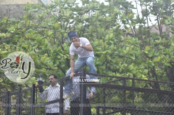 Shah Rukh Khan climbs up the fence to blow a flying kiss to his fans