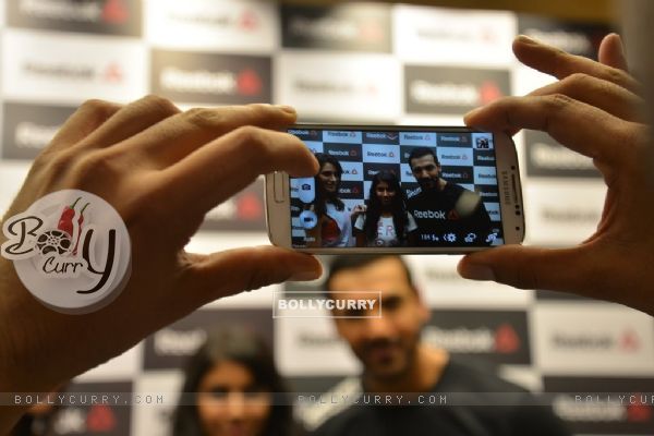 A fan clicking pic with John Abraham and Nargis Fakhri at the Press Meet of Reebok