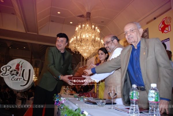 Anu Malik receiving a trophy at Giant Awards in Trident