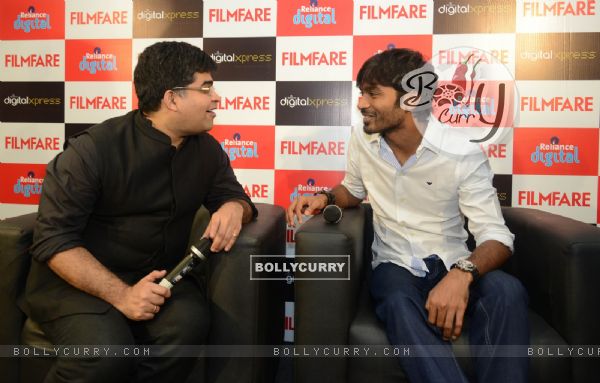 Dhanush chats with Jitesh Pillai at the Filmfare Readers Meet at the Reliance Digital Store
