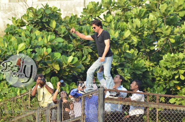 Shahrukh Khan climbs over the railing to greet his fans