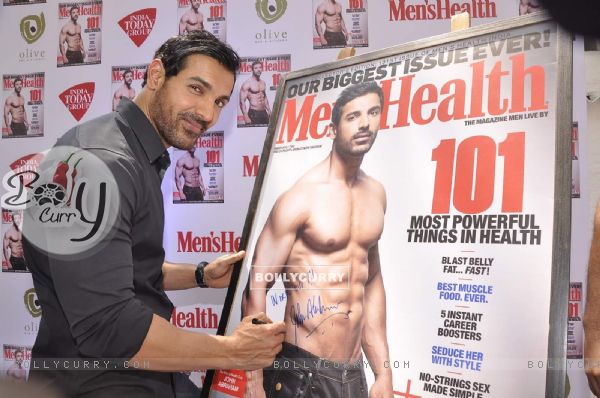 John Abraham signs his autograph at the Cover of Men's Health March Edition