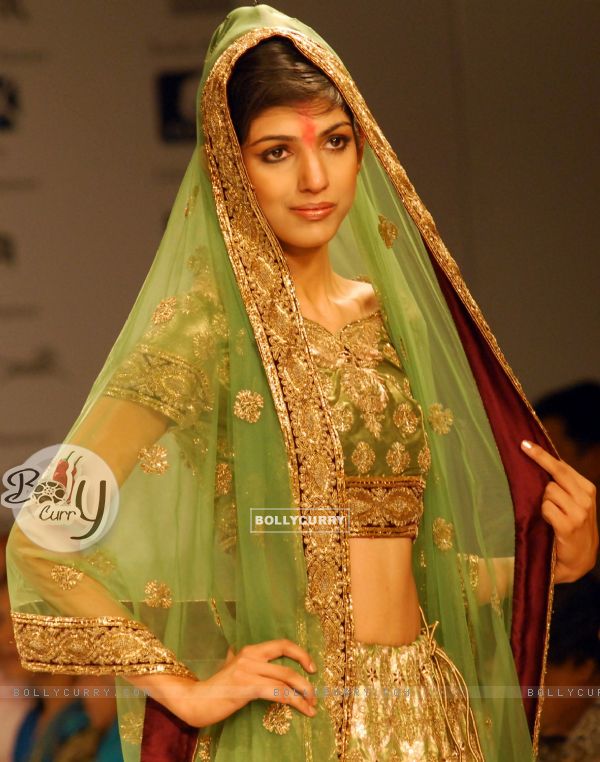 A model catwalks in an outfit design by a designer at the Kolkata Fashion Week in Kolkata on 10th Sep 2009