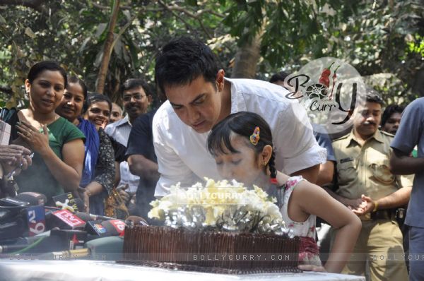 Aamir KHan blows his 45rd birthday candles with one of his child fans as he celebrated his birthday with media today at his home in Mumbai