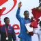 Geoffrey Mutai (R) of Kenya waves after winning gold in the men's  event of Delhi half Marathon, along with silver medallist Lelisa Desisa (L) of Ethiopia and bronze medal winner Yacob Yarso of Ethopia during the victory ceremony , in New Delhi